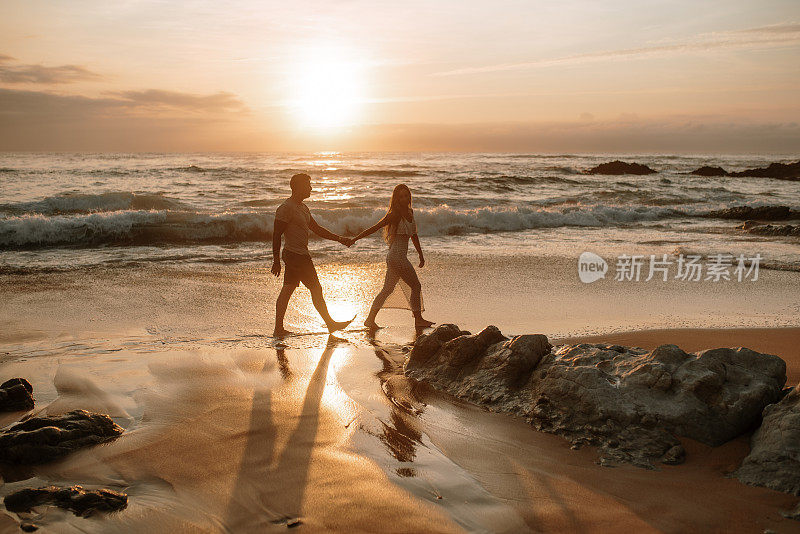 Young couple  walking and holding hands at a beach